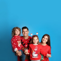 Family in Christmas sweaters on blue background