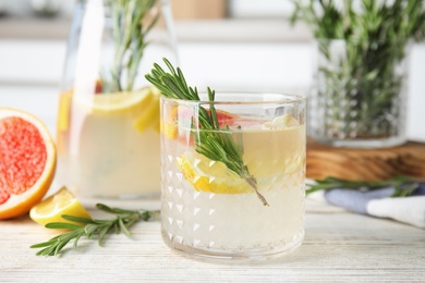 Photo of Refreshing grapefruit cocktail with rosemary on table