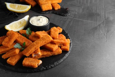 Photo of Tasty fresh fish fingers served on black table, space for text