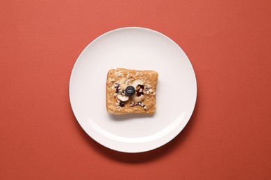 Toast with tasty nut butter, blueberry and cashews on coral background, top view