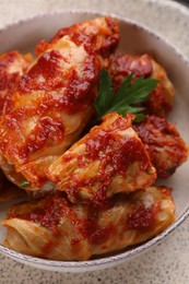 Photo of Delicious stuffed cabbage rolls cooked with homemade tomato sauce in bowl, above view