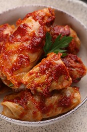 Delicious stuffed cabbage rolls cooked with homemade tomato sauce in bowl, above view