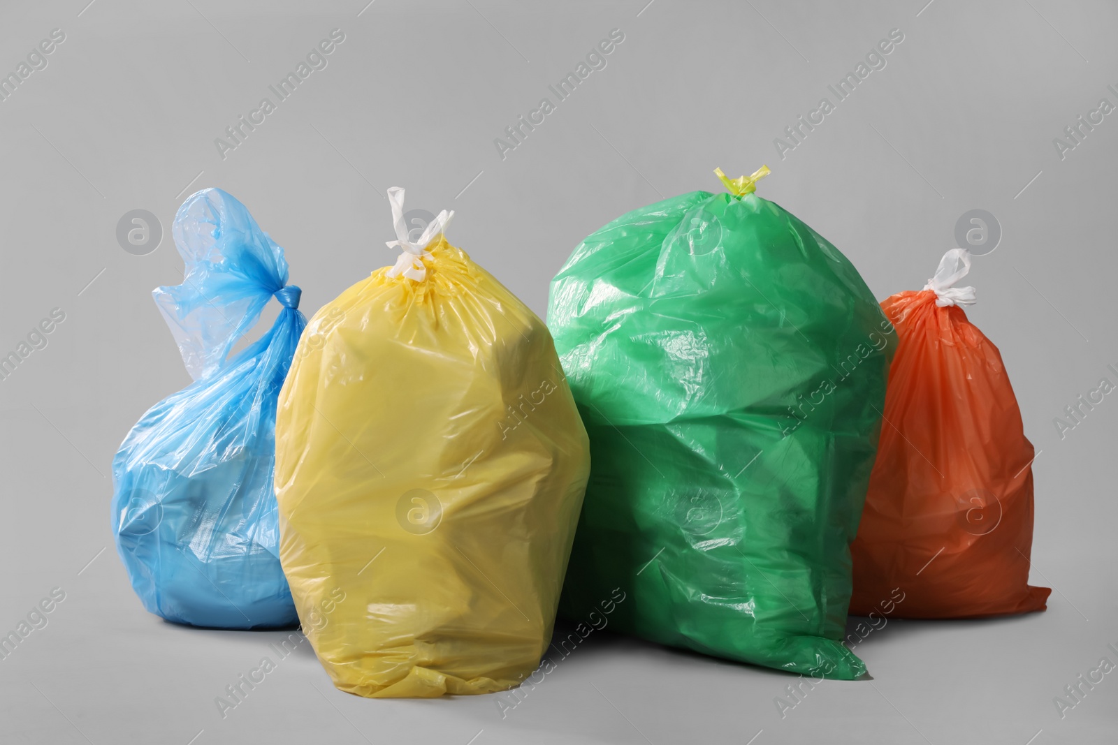 Photo of Trash bags full of garbage on grey background