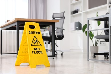 Photo of Cleaning service. Wet floor sign in office, space for text