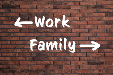 Image of Life choice. Arrows with words work and family on brick wall 