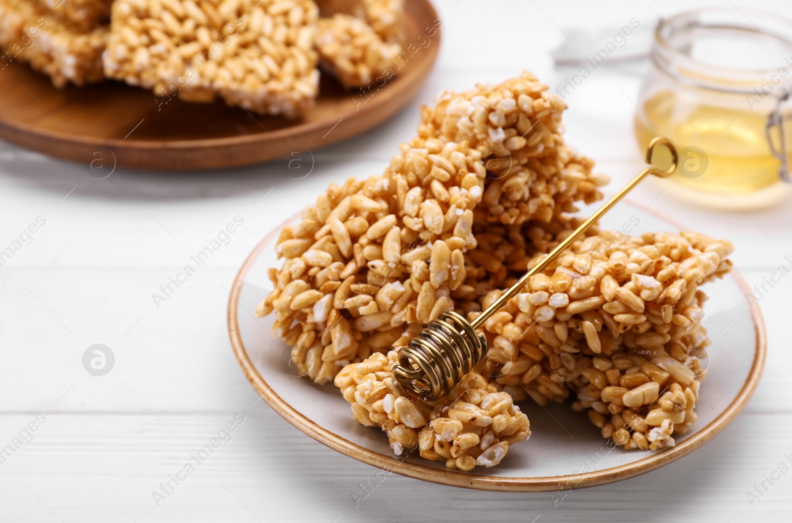 Photo of Puffed rice bars (kozinaki) on white wooden table, closeup