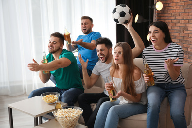 Group of friends watching football at home