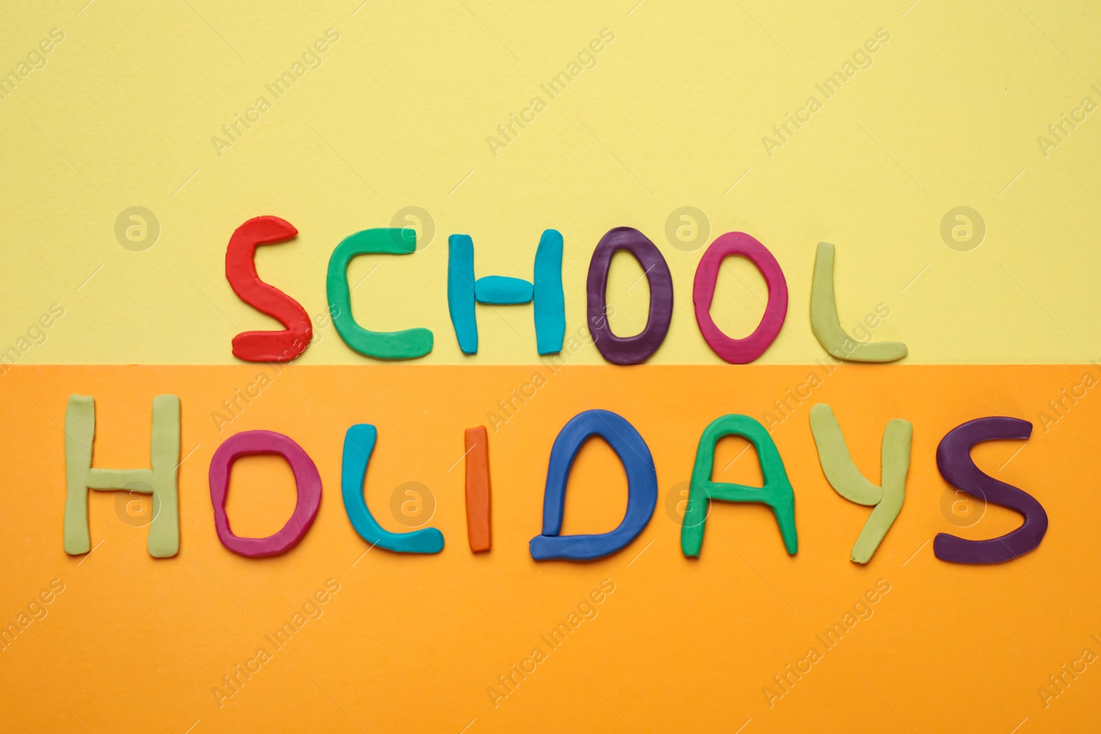 Photo of Phrase School Holidays made of modeling clay on color background, top view