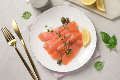 Photo of Delicious salmon carpaccio served on light grey table, flat lay