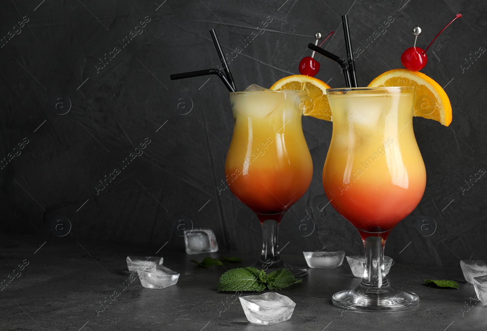 Photo of Just made appetizing cocktails Sex on the Beach, black background. Space for text