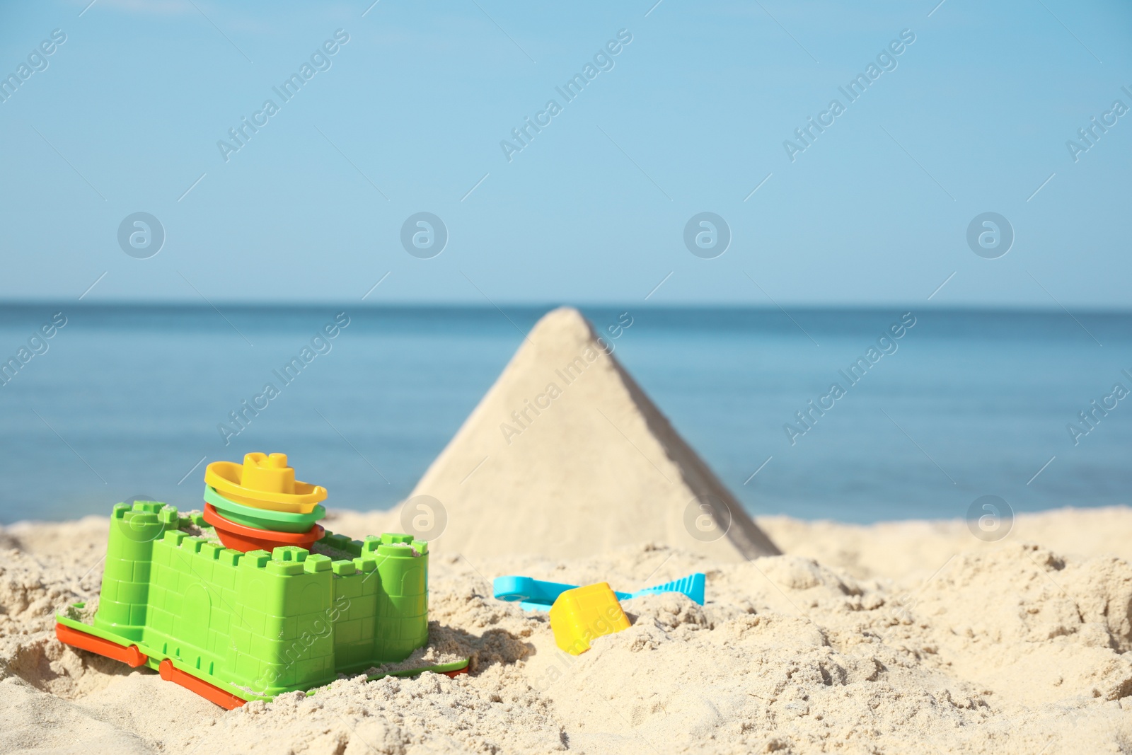 Photo of Different child plastic toys on sandy beach