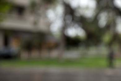 Photo of Blurred view of green trees on city street. Bokeh effect