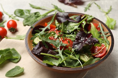 Photo of Tasty fresh vegetarian salad and ingredients on grey table, closeup