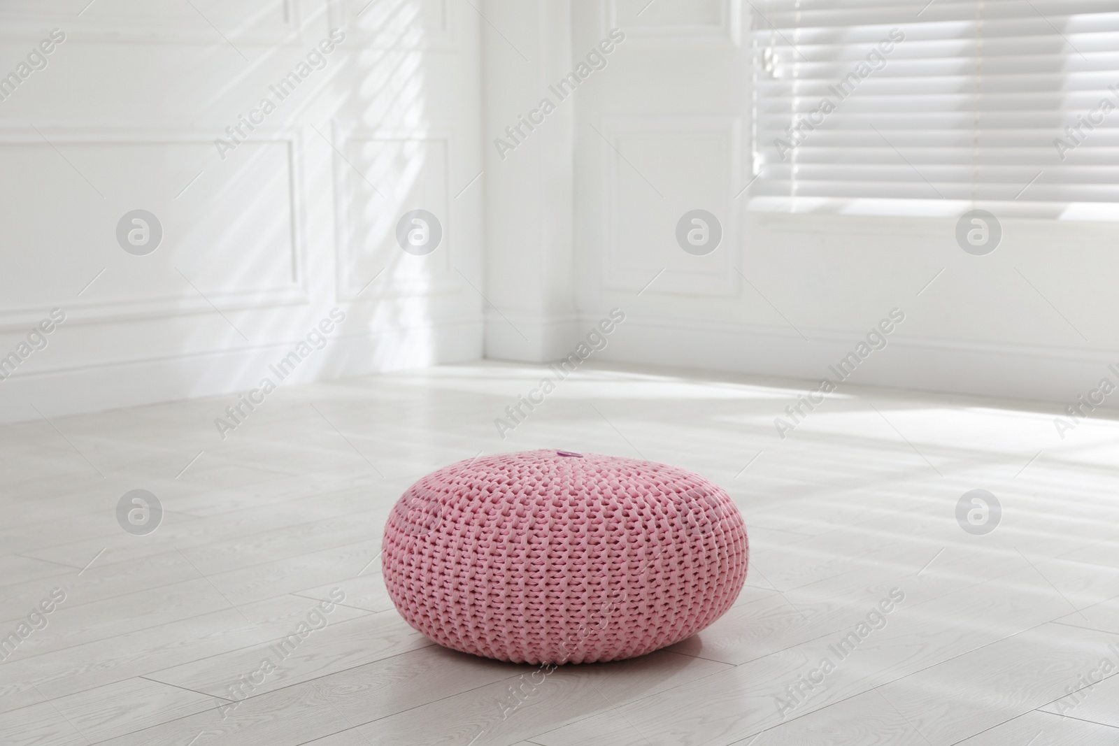 Photo of Stylish pink pouf in room. Home design
