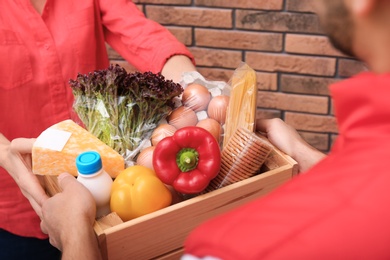 Photo of Male courier delivering food to client indoors, closeup