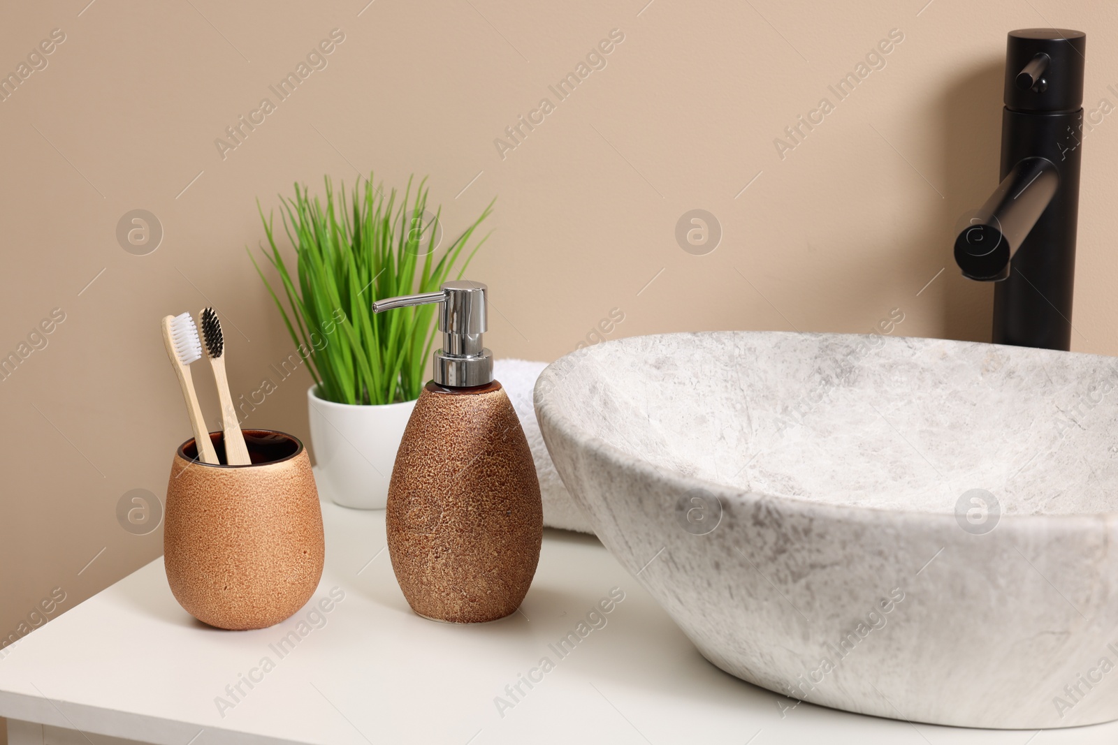 Photo of Different bath accessories and personal care products near sink on bathroom vanity