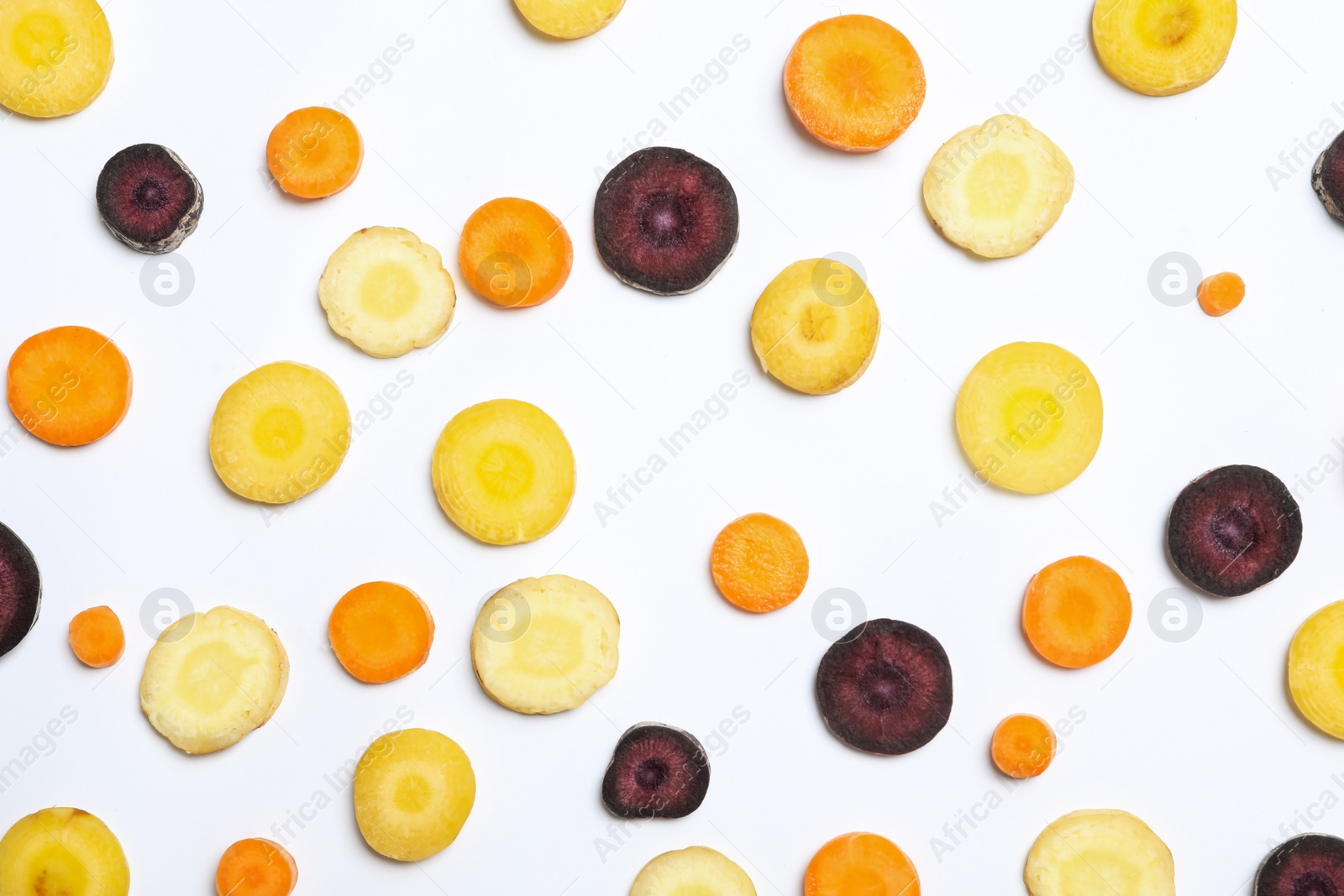 Photo of Slices of raw color carrots on white background, top view