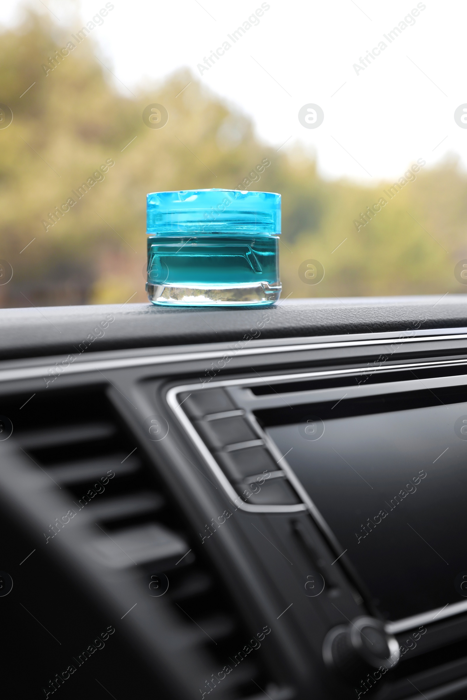 Photo of Stylish air freshener on dashboard in car