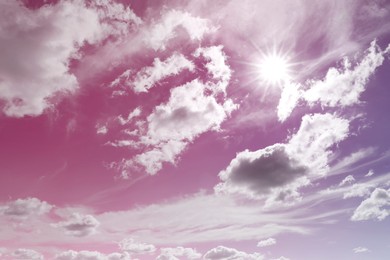 Image of Amazing pink and purple sky with bright sun and fluffy clouds