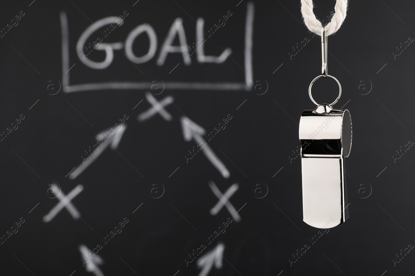 Photo of Referee whistle against chalkboard with game scheme, closeup. Space for text