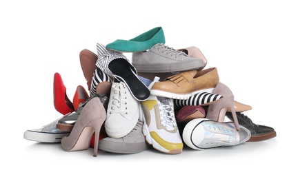 Photo of Pile of female shoes on white background