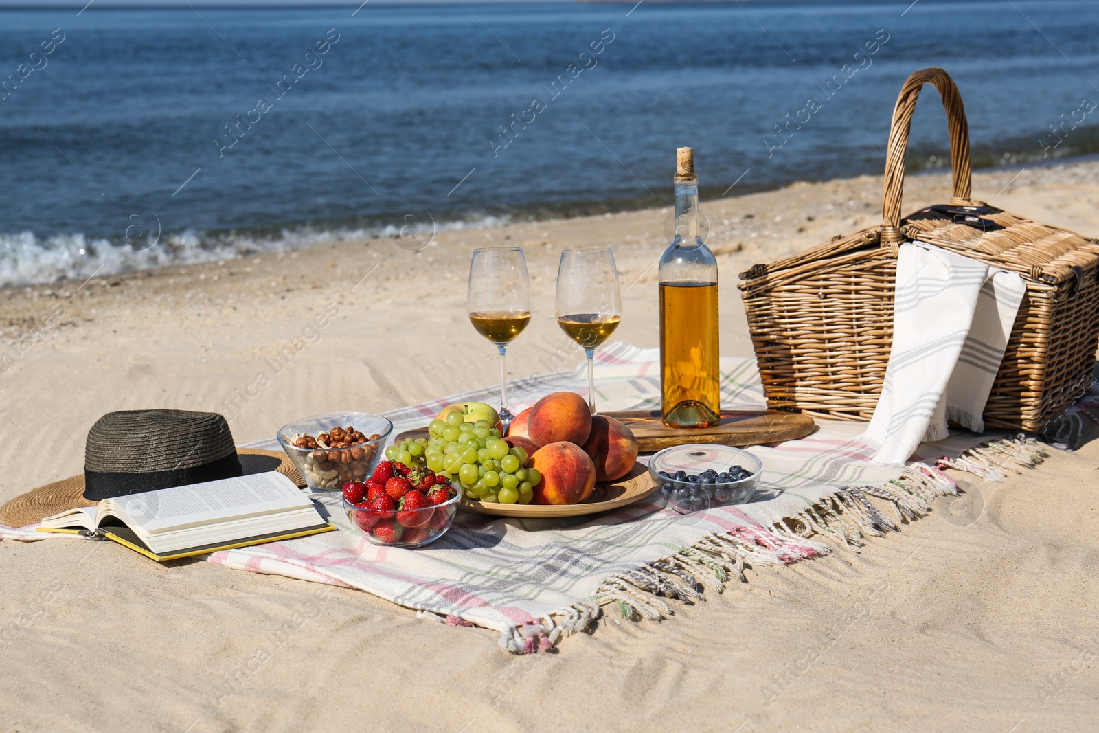 Photo of Food and wine on beach. Summer picnic