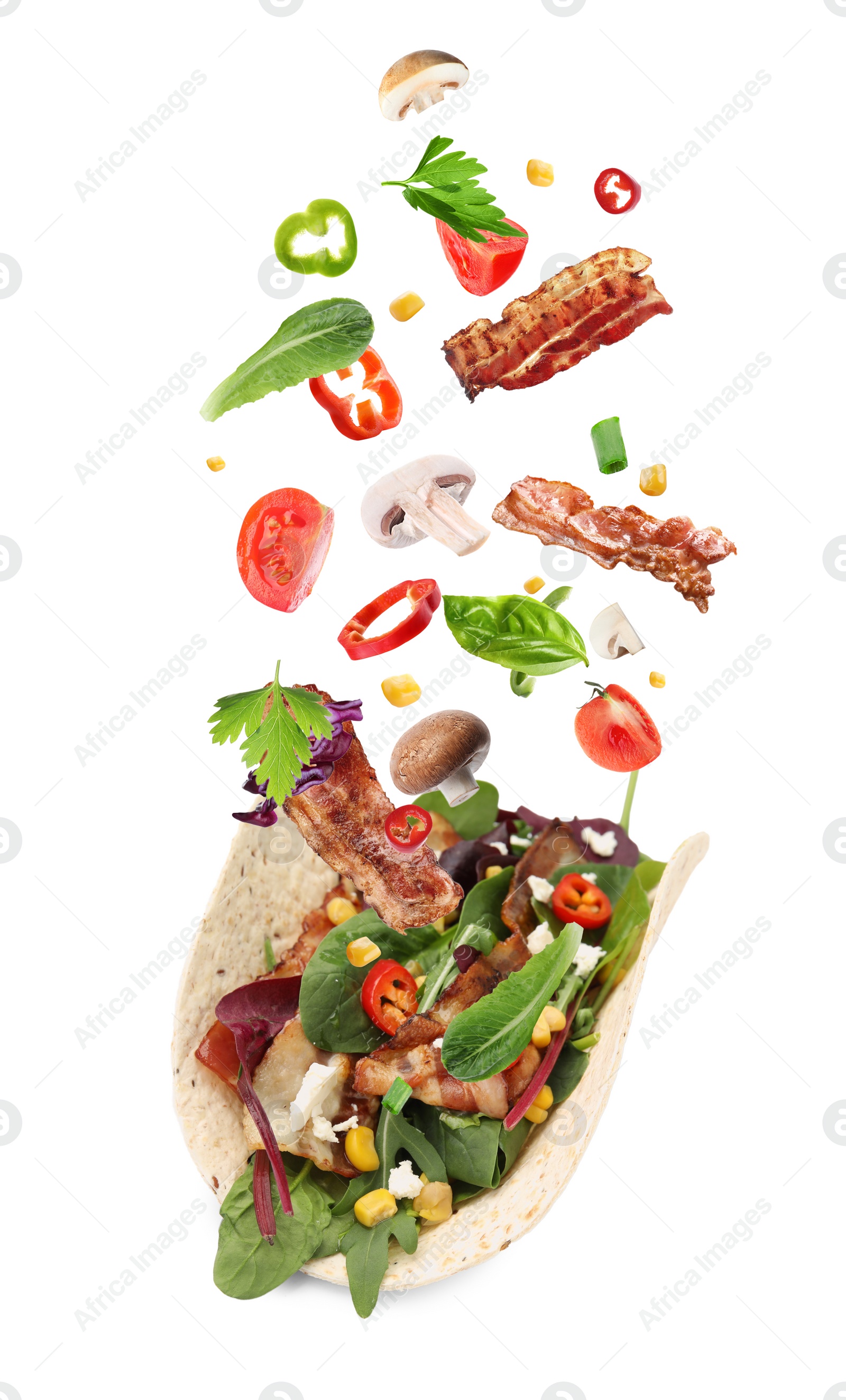 Image of Delicious tacos. Ingredients falling into tortilla on white background