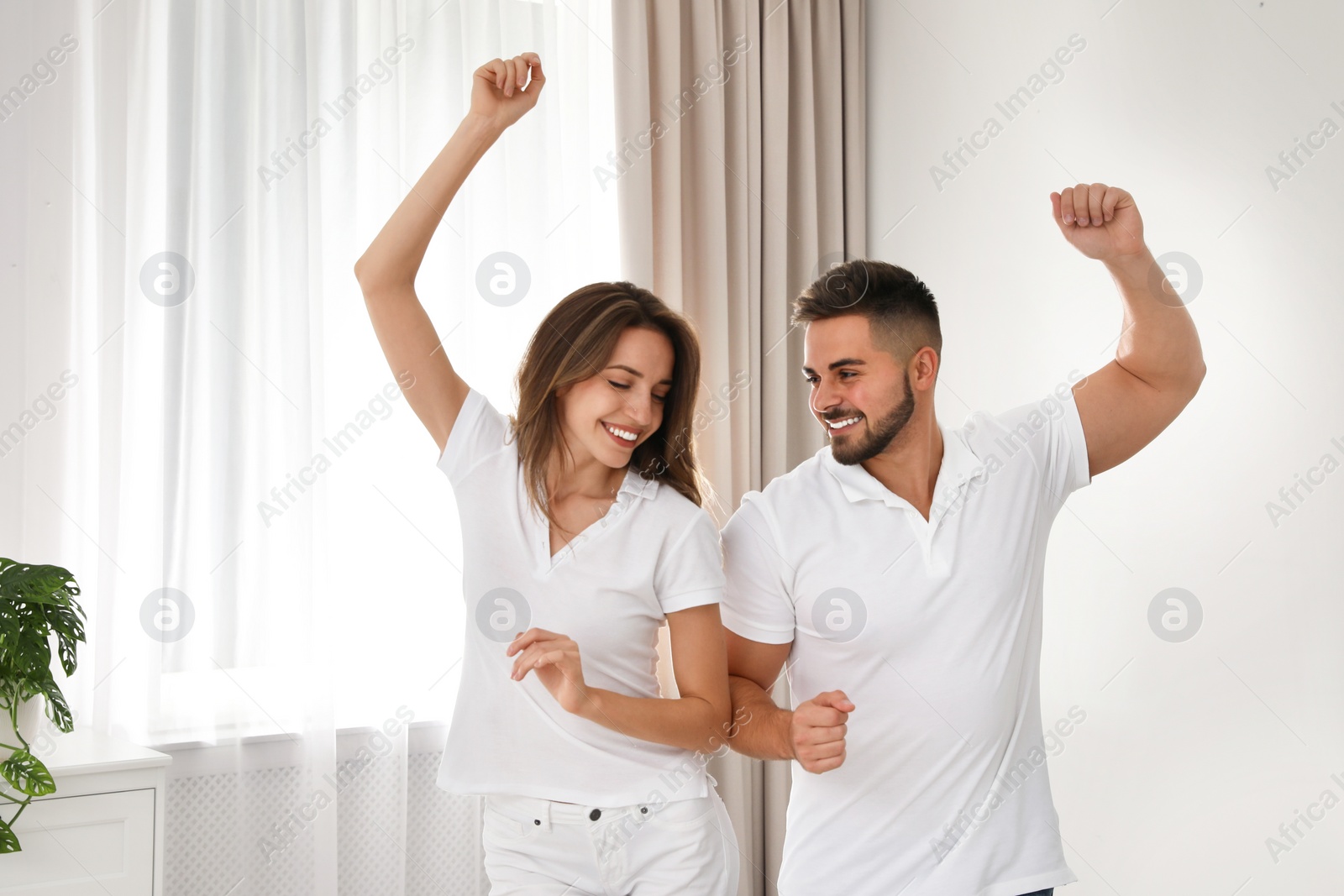 Photo of Lovely young couple dancing together at home