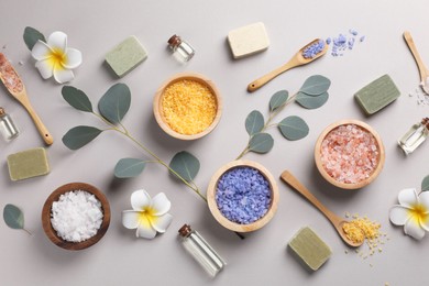 Flat lay composition with spa products and eucalyptus branches on grey background