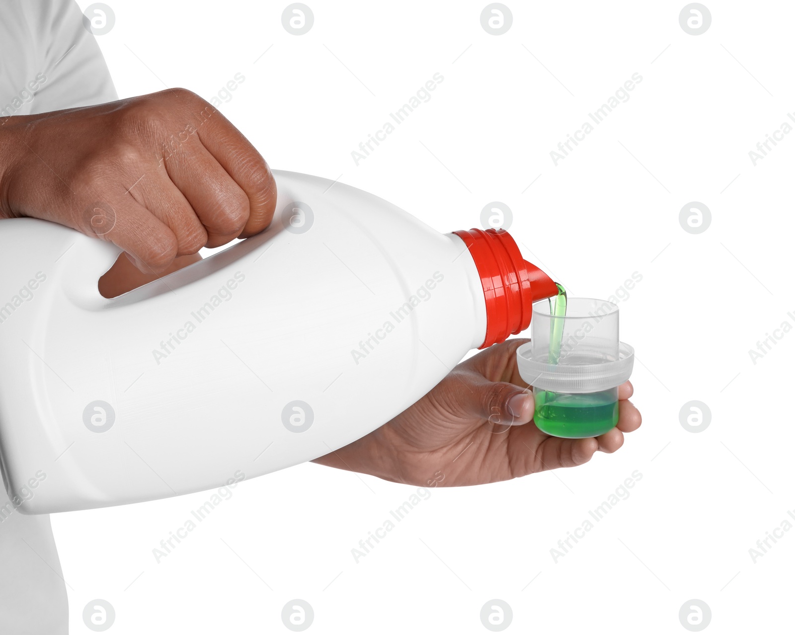 Photo of Woman pouring fabric softener from bottle into cap on white background, closeup