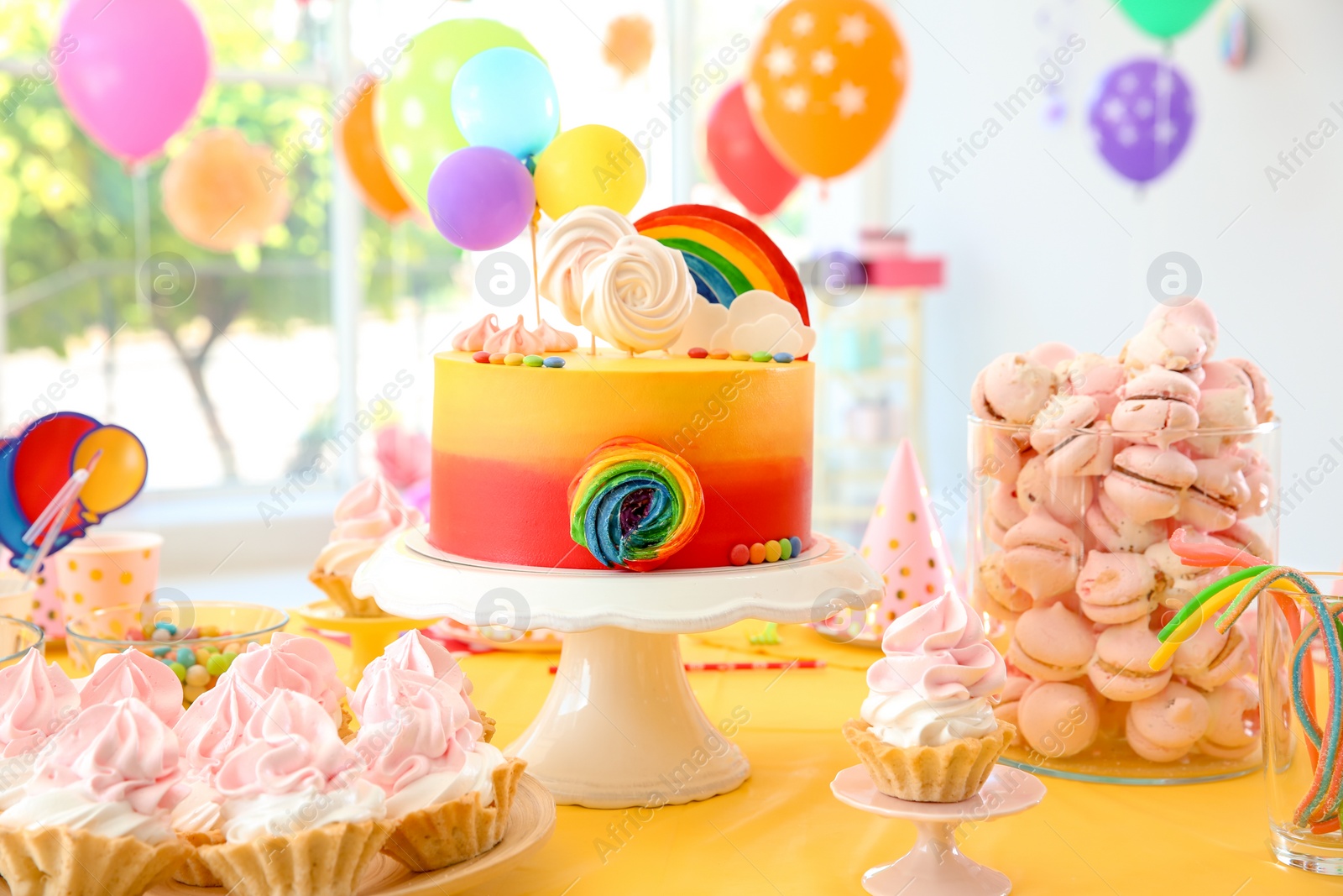 Photo of Table with birthday cake and delicious treats indoors