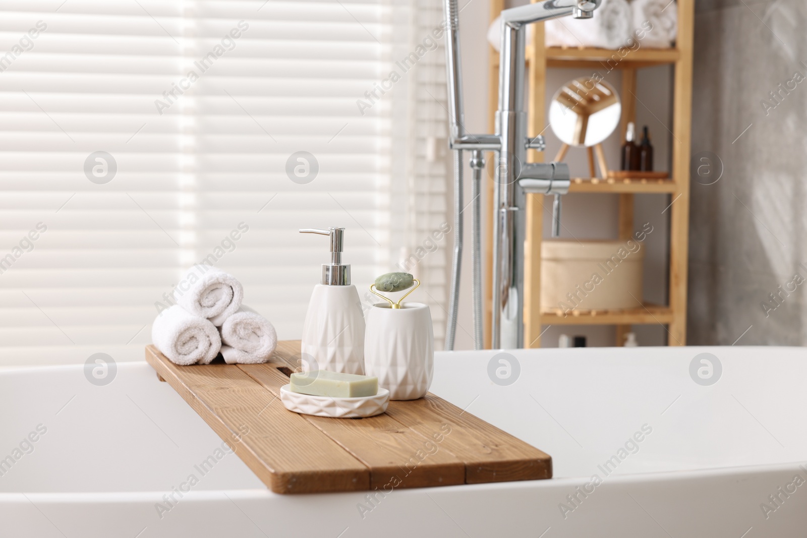 Photo of Different personal care products on bath tub in bathroom