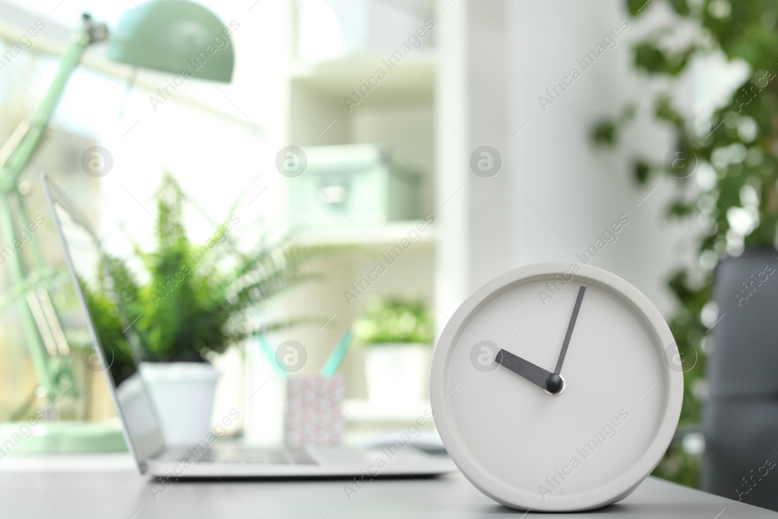 Photo of Analog alarm clock on table in office. Time to work