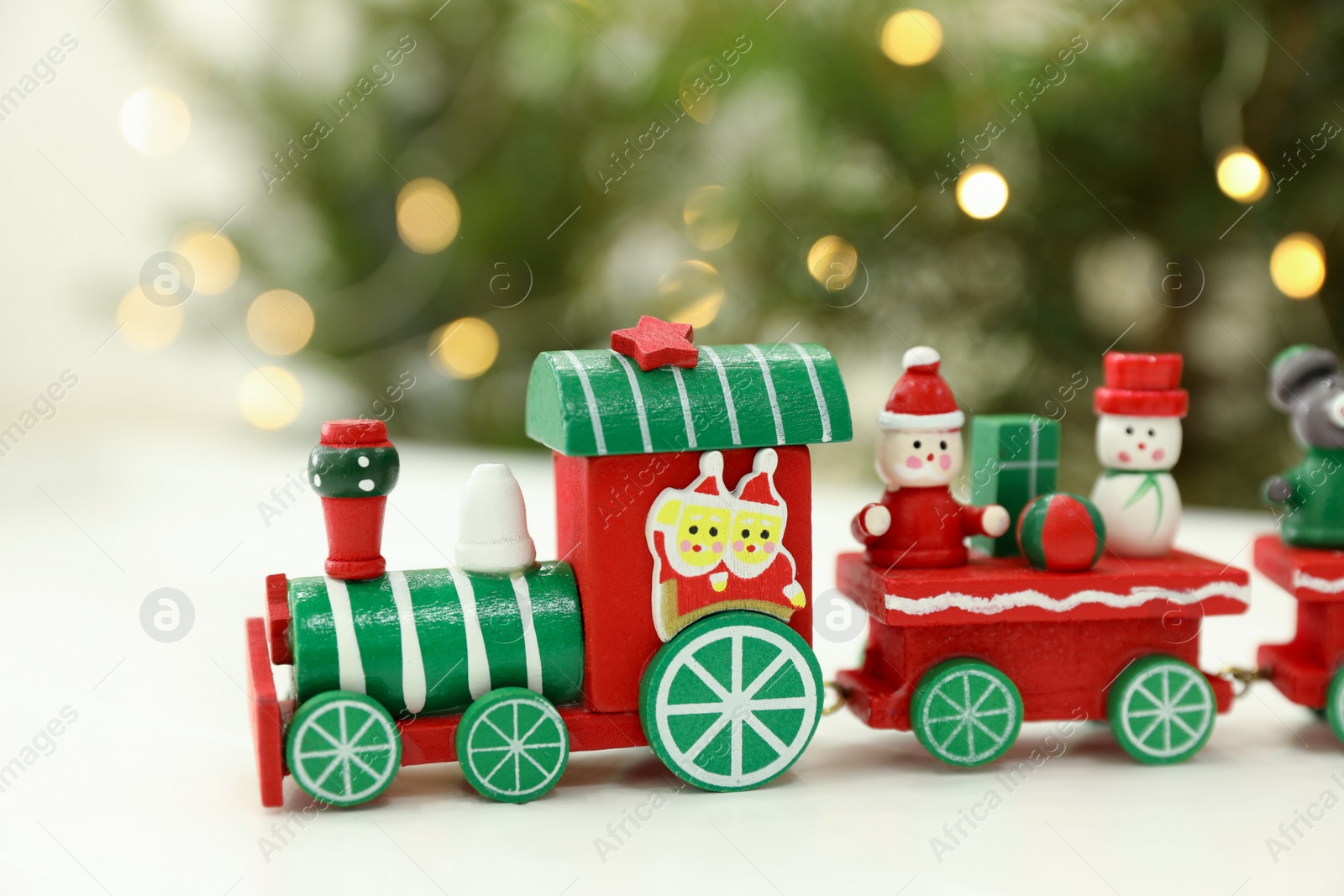 Photo of Bright toy train on white table, closeup. Christmas atmosphere