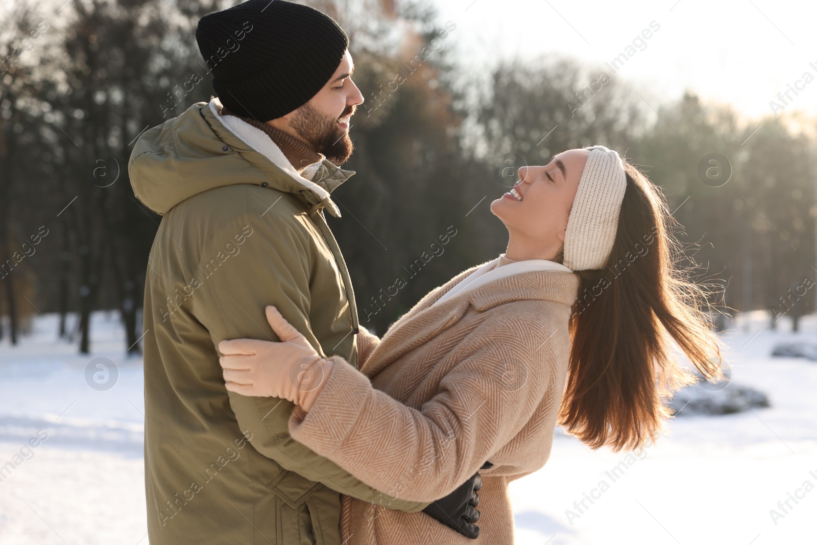 Photo of Beautiful happy couple in snowy park on winter day