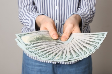 Photo of Woman with American money on grey background, closeup