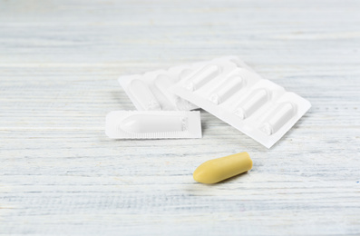 Photo of Suppositories on white wooden table. Hemorrhoid treatment