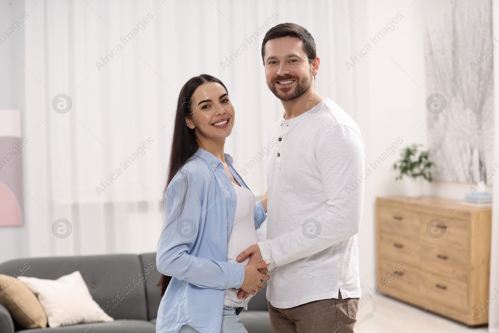 Photo of Happy pregnant woman with her husband at home