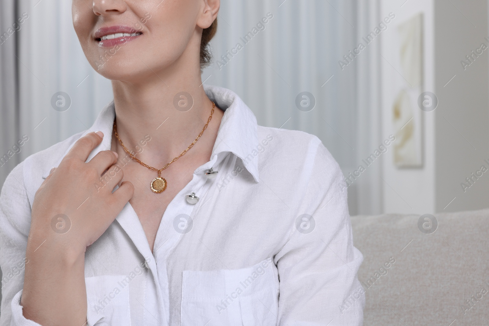 Photo of Woman with elegant necklace on blurred background, closeup. Space for text