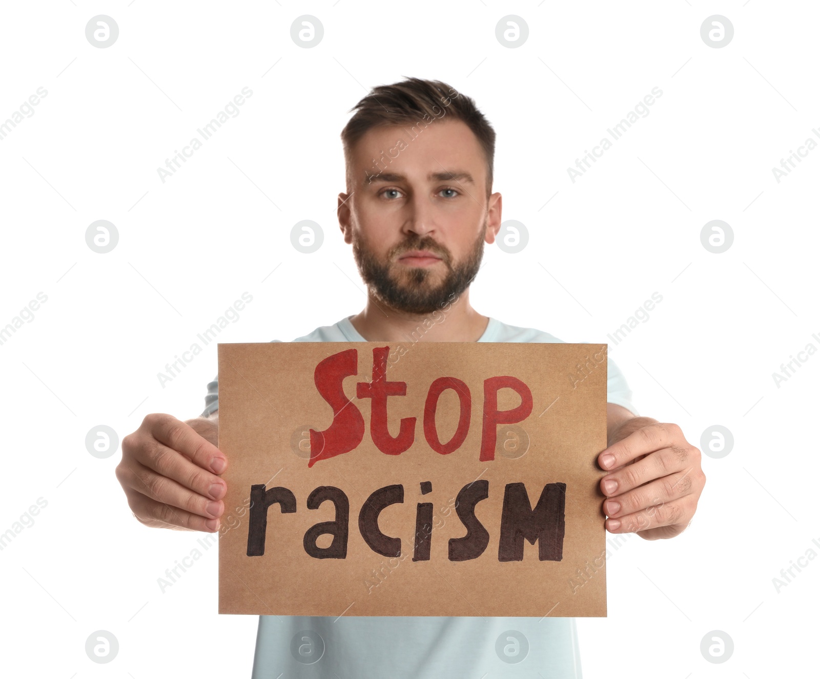 Photo of Young man holding sign with phrase Stop Racism on white background