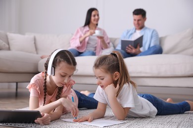 Photo of Family in living room with comfortable sofa, focus on children