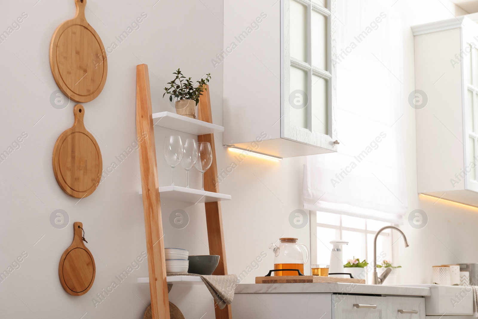 Photo of Stylish kitchen room interior with wooden ladder near white wall