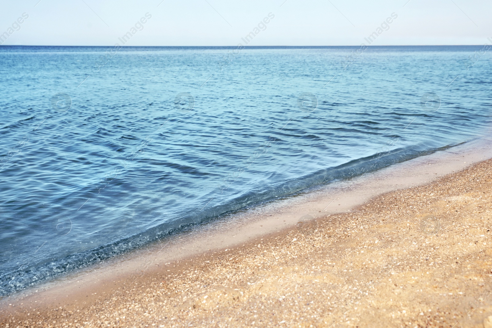 Photo of View of sea water and beach sand on sunny summer day