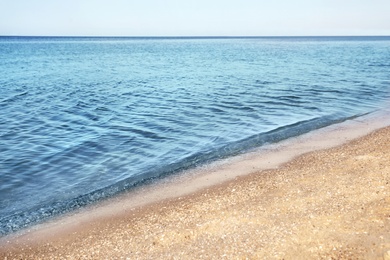 Photo of View of sea water and beach sand on sunny summer day