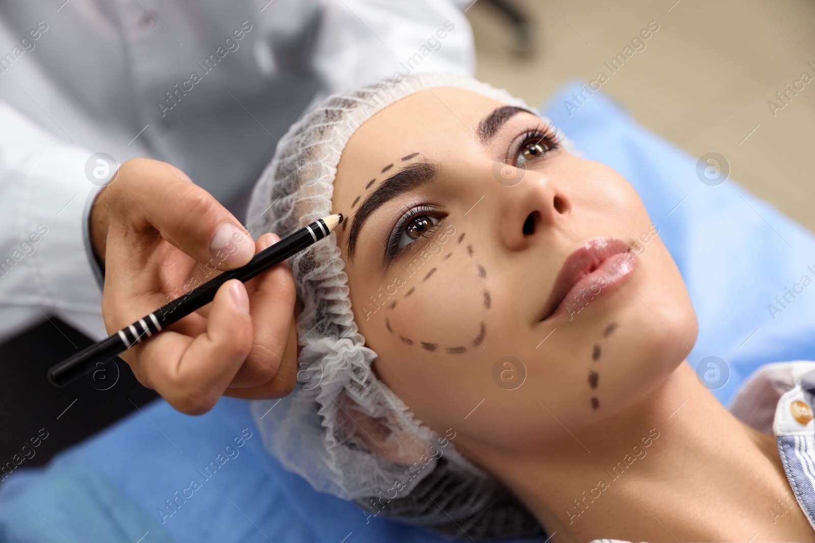 Photo of Doctor preparing female patient for cosmetic surgery in clinic