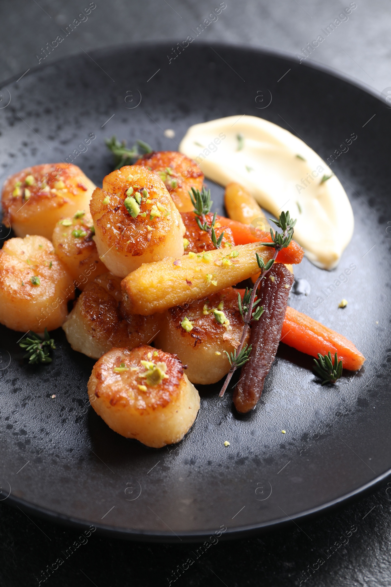 Photo of Delicious fried scallops on dark gray table, closeup