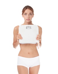 Worried young woman holding bathroom scales on white background. Weight loss diet