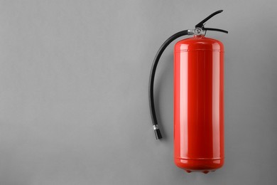 Photo of Fire extinguisher on light grey background, top view. Space for text