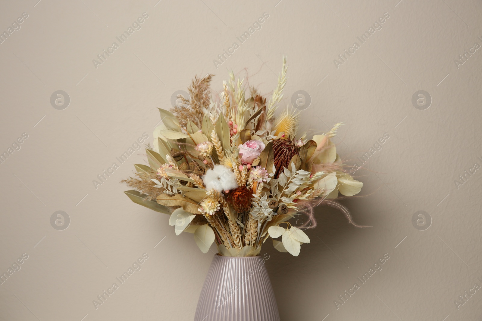 Photo of Beautiful dried flower bouquet in ceramic vase against light grey background
