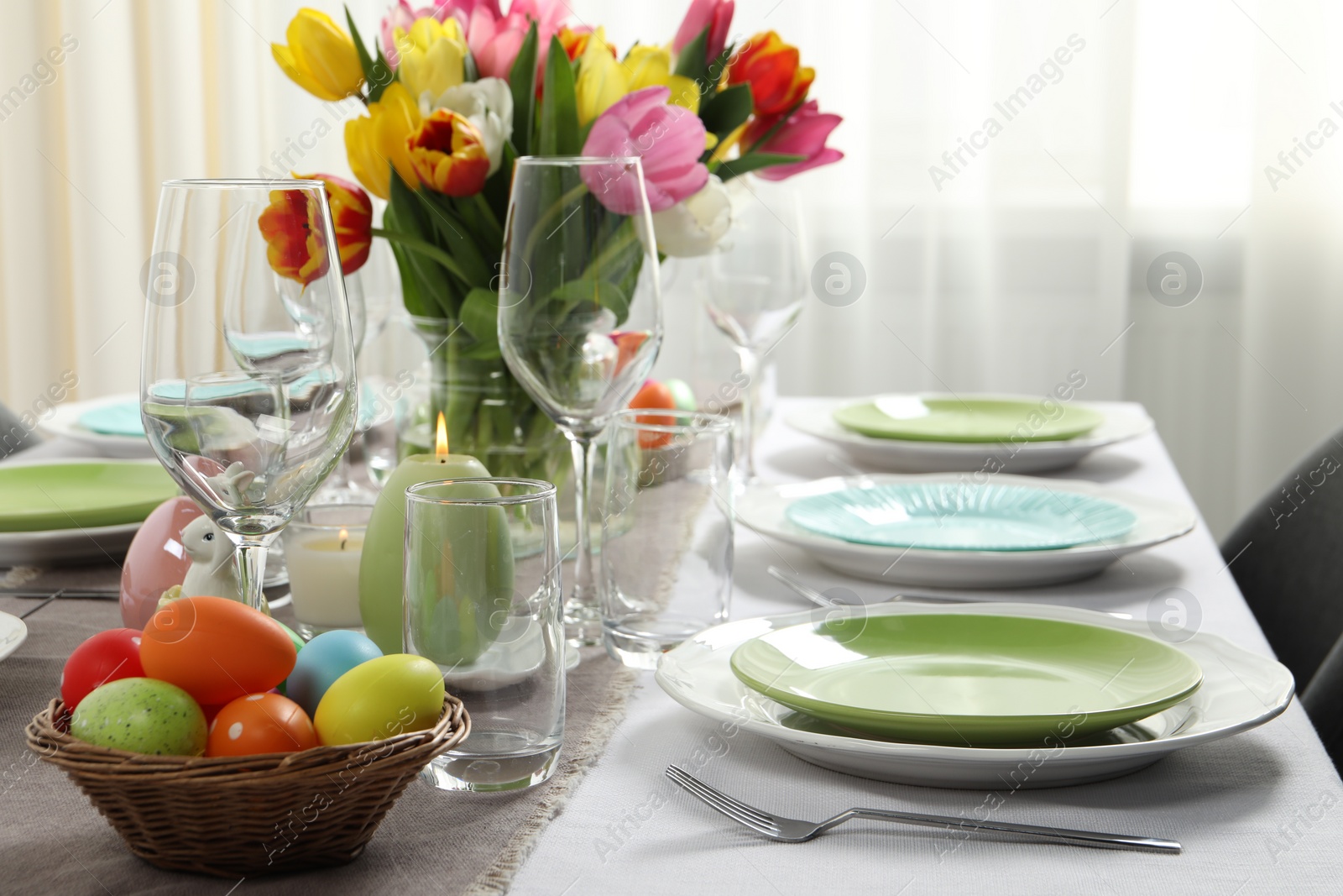 Photo of Easter celebration. Festive table setting with beautiful flowers and painted eggs